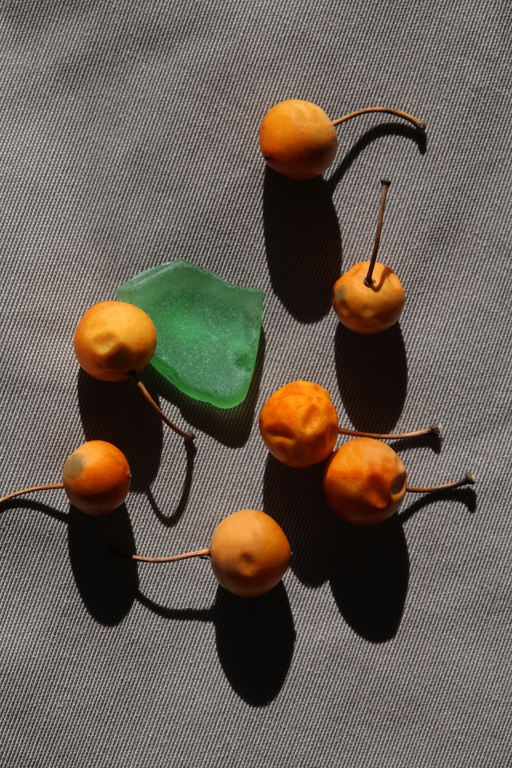 Green Glass Fragment and Golden-Orange Fruits on Gray Pants, 2020